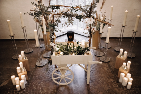 Eine Dekoration mit einem weißen Wagen, Blumen und Kerzen